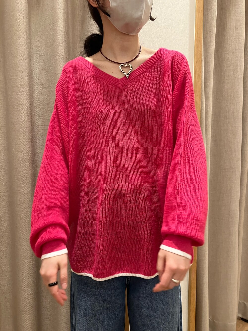 ブルー系のデニムパンツ、ピンク系のニット/セーター、ホワイト系のサンダルを着用したレディースの春コーディネートの3枚目の写真