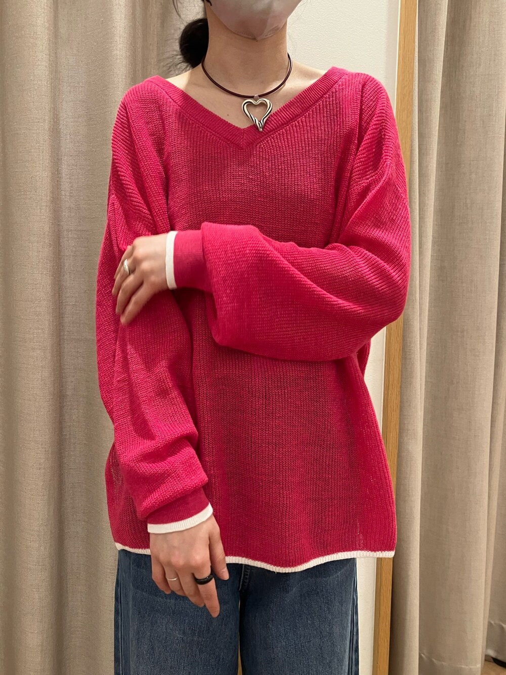 ブルー系のデニムパンツ、ピンク系のニット/セーター、ホワイト系のサンダルを着用したレディースの春コーディネートの4枚目の写真