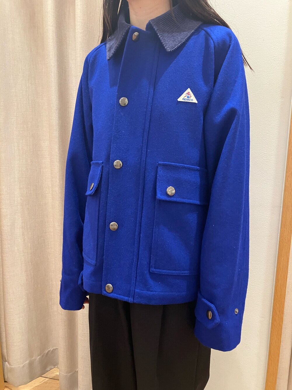 ブルー系のテーラードジャケット、ブラック系のダウンベスト、パープル系のTシャツ/カットソーを着用したレディースの夏コーディネートの5枚目の写真