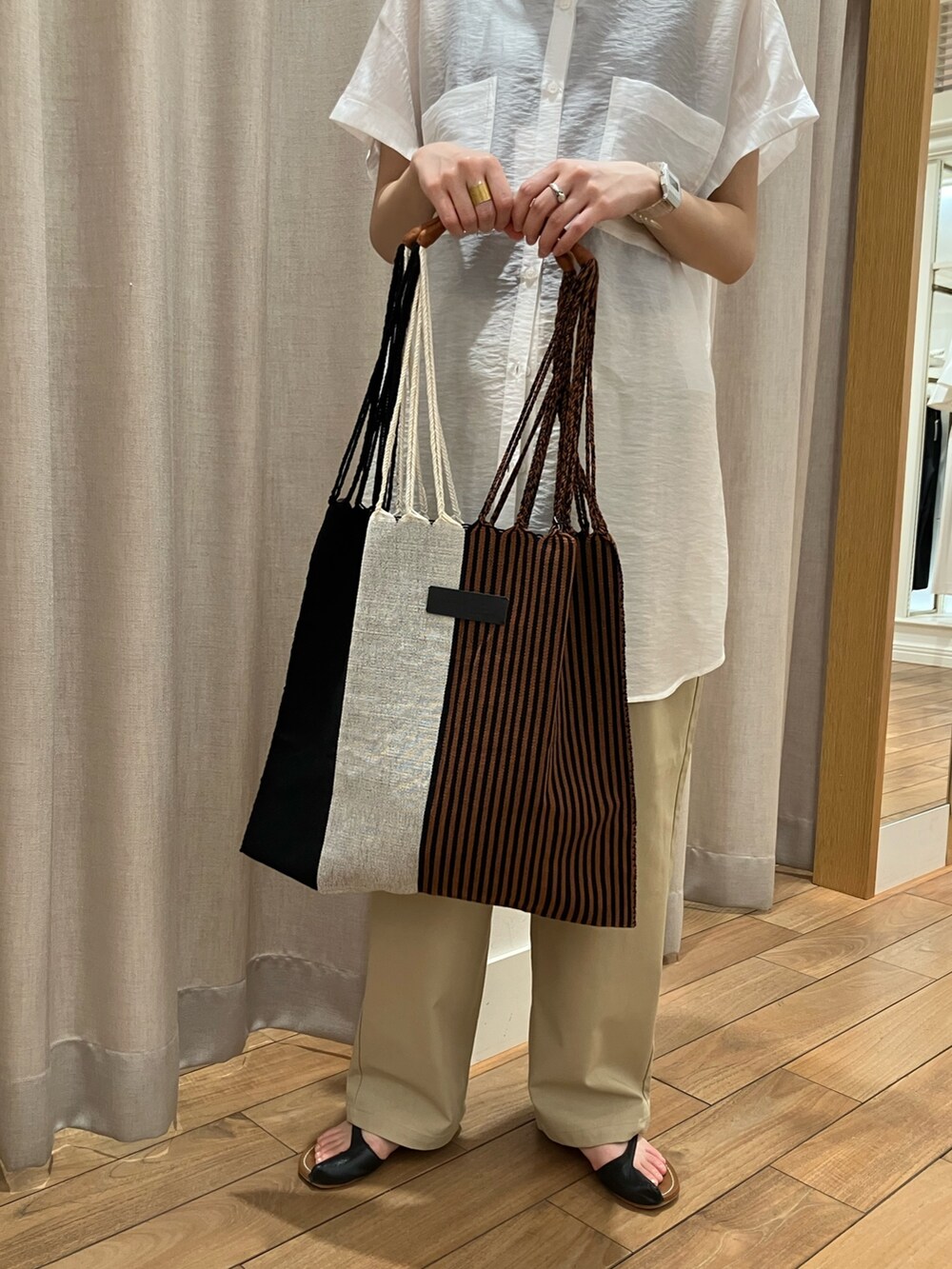 ベージュ系のその他パンツ、ベージュ系のショルダーバッグ、ホワイト系のシャツ/ブラウスを着用したレディースの夏コーディネートの9枚目の写真