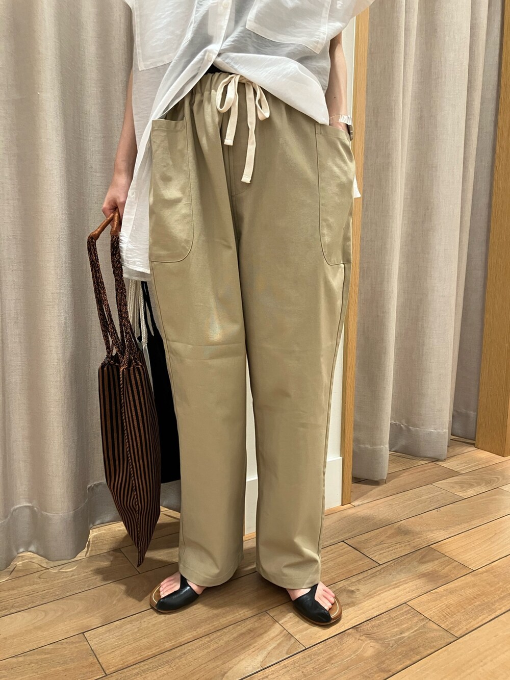 ベージュ系のその他パンツ、ベージュ系のショルダーバッグ、ホワイト系のシャツ/ブラウスを着用したレディースの夏コーディネートの10枚目の写真