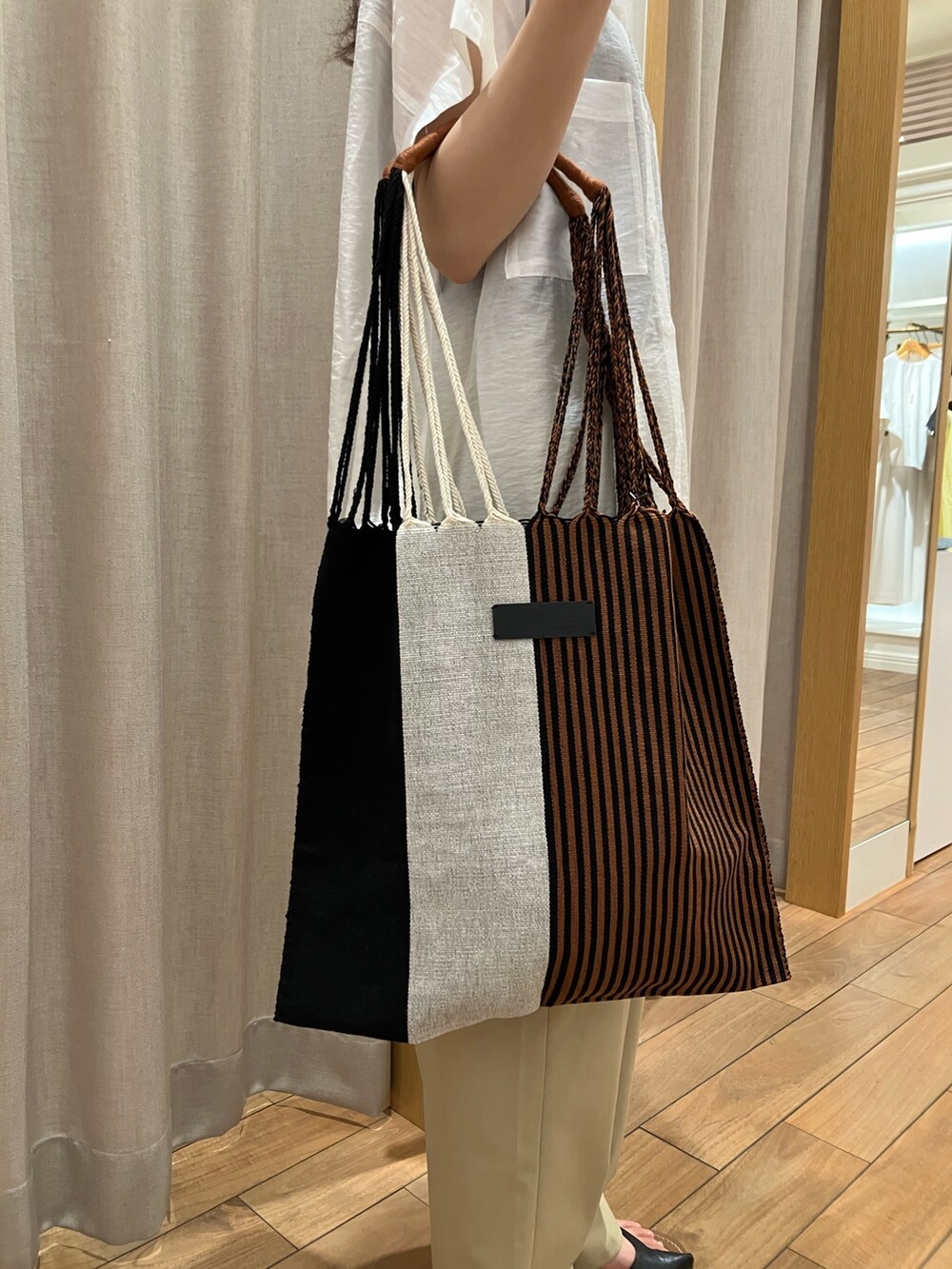 ベージュ系のその他パンツ、ベージュ系のショルダーバッグ、ホワイト系のシャツ/ブラウスを着用したレディースの夏コーディネートの8枚目の写真