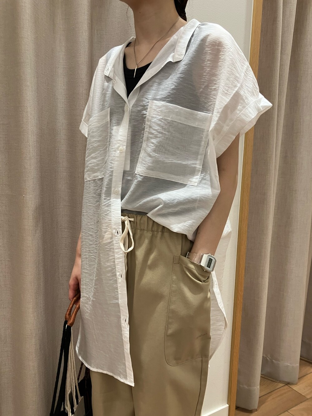 ベージュ系のその他パンツ、ベージュ系のショルダーバッグ、ホワイト系のシャツ/ブラウスを着用したレディースの夏コーディネートの5枚目の写真