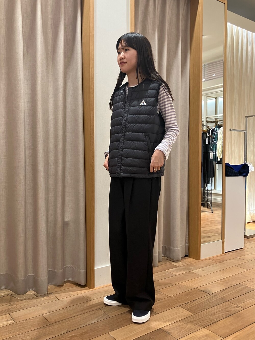 ブルー系のテーラードジャケット、ブラック系のダウンベスト、パープル系のTシャツ/カットソーを着用したレディースの夏コーディネートの9枚目の写真