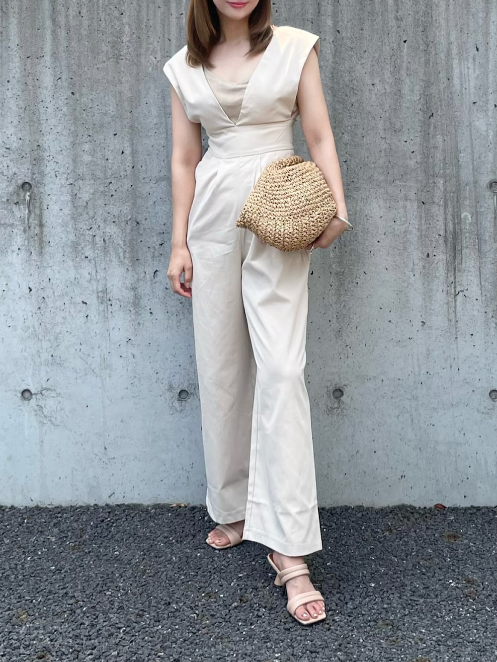 ベージュ系のかごバッグ、ベージュ系のサロペット/オーバーオール、ベージュ系のキャミソールを着用したレディースの夏コーディネートの2枚目の写真