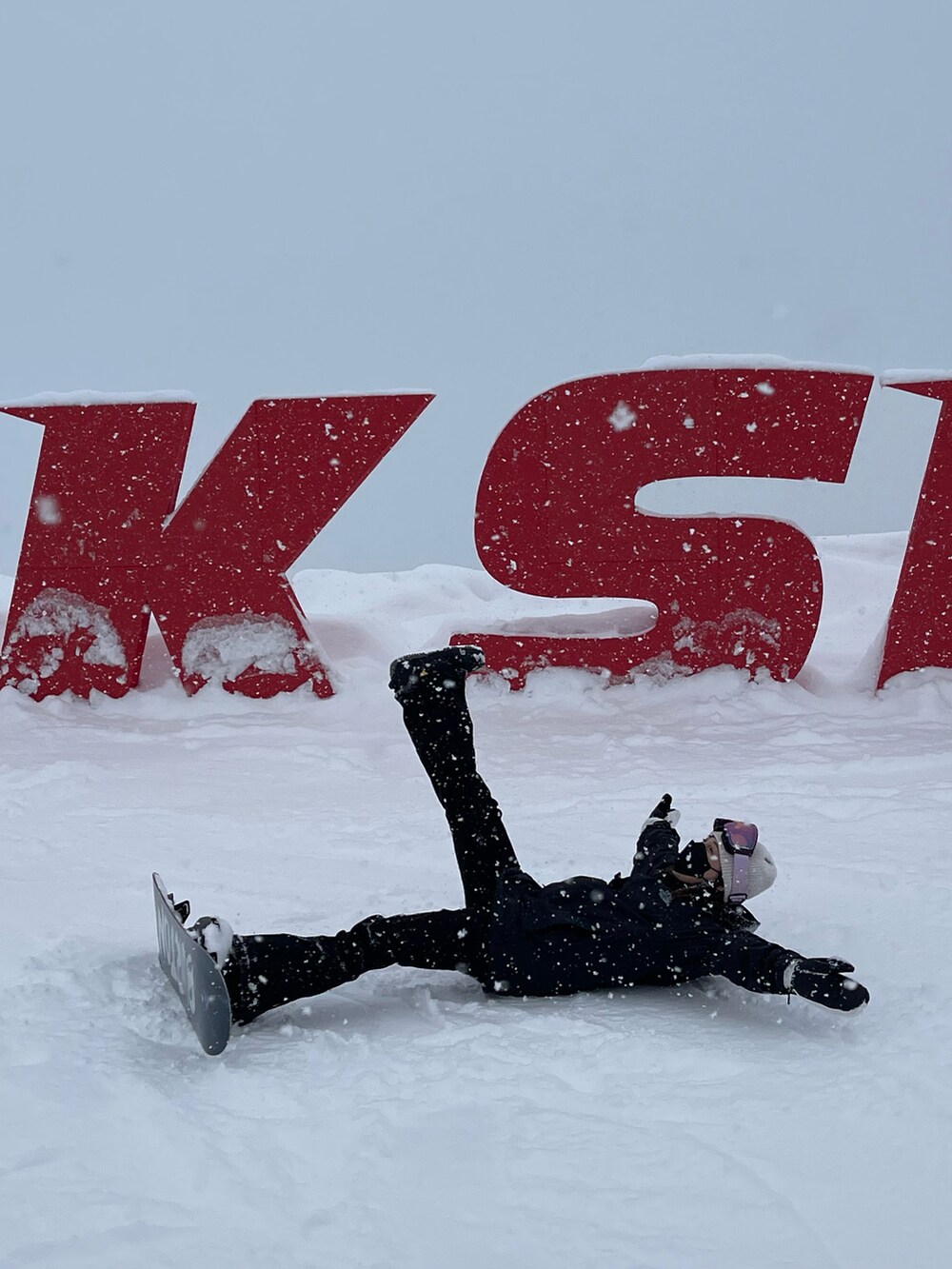 ブラック系のマウンテンパーカー、ブラック系のその他パンツ、ピンク系のスポーツグッズを着用したレディースの冬コーディネートの4枚目の写真