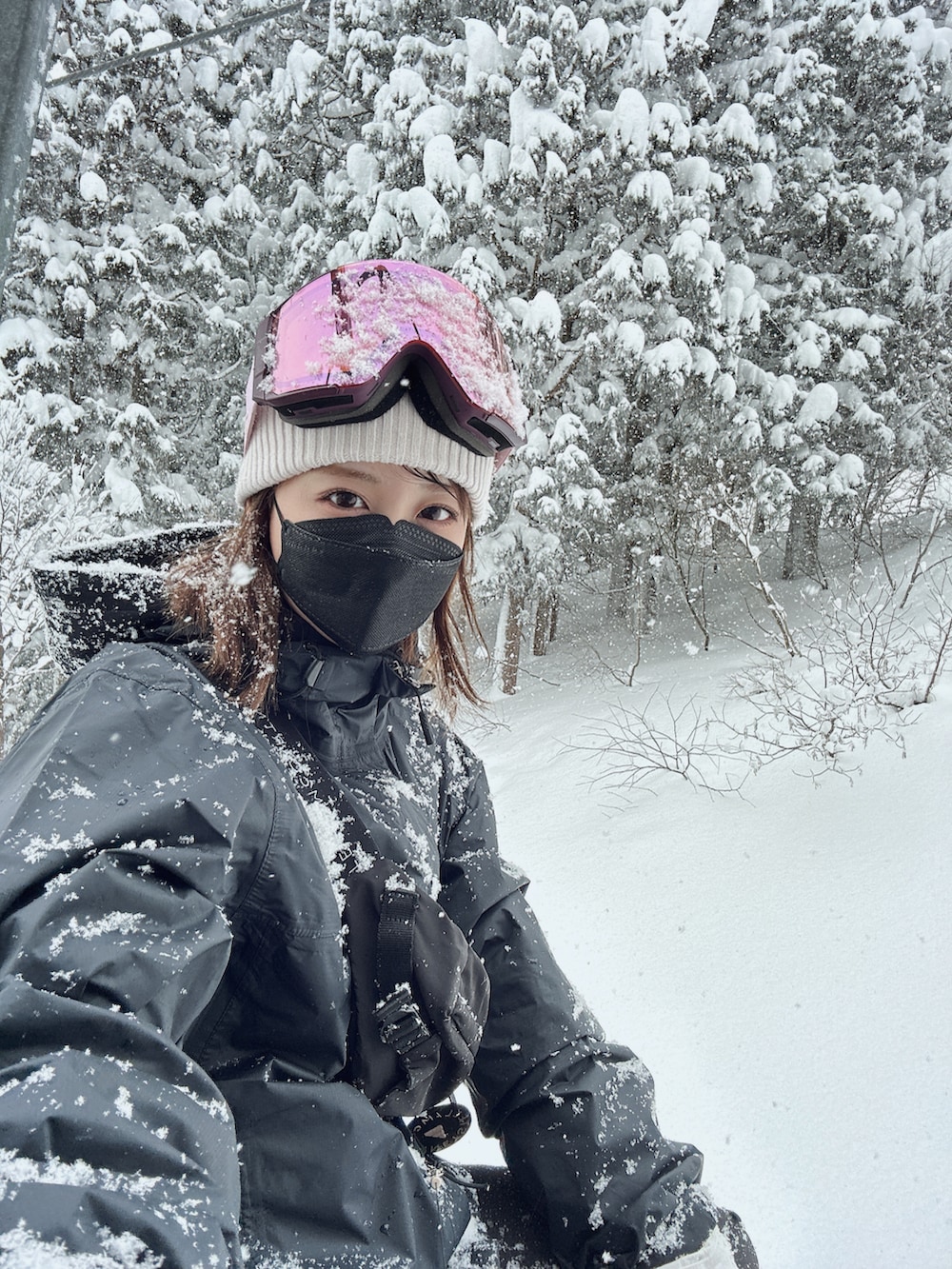 ブラック系のマウンテンパーカー、ブラック系のその他パンツ、ピンク系のスポーツグッズを着用したレディースの冬コーディネートの2枚目の写真