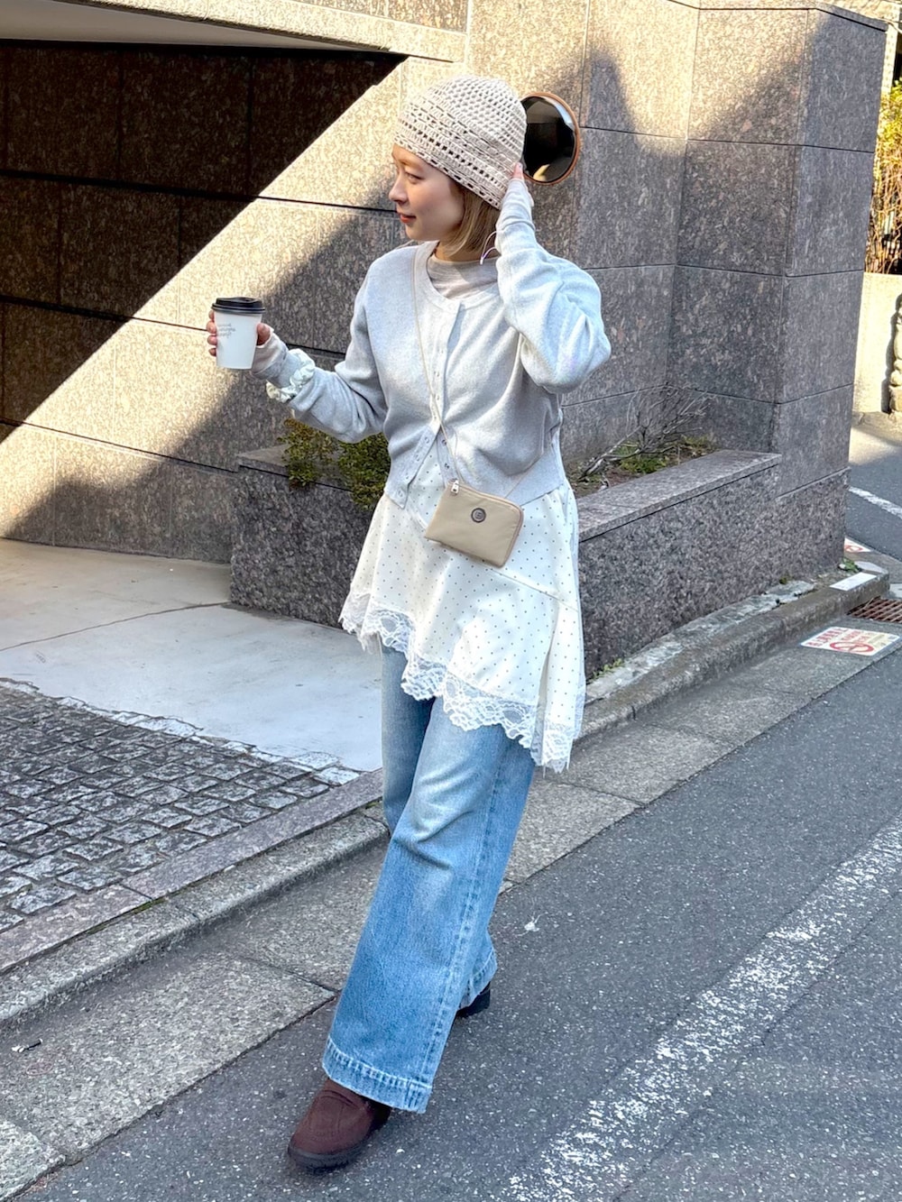 グレー系のニット/セーター、ホワイト系のワンピース、ホワイト系のニットキャップ/ビーニーを着用したレディースの春コーディネートの3枚目の写真