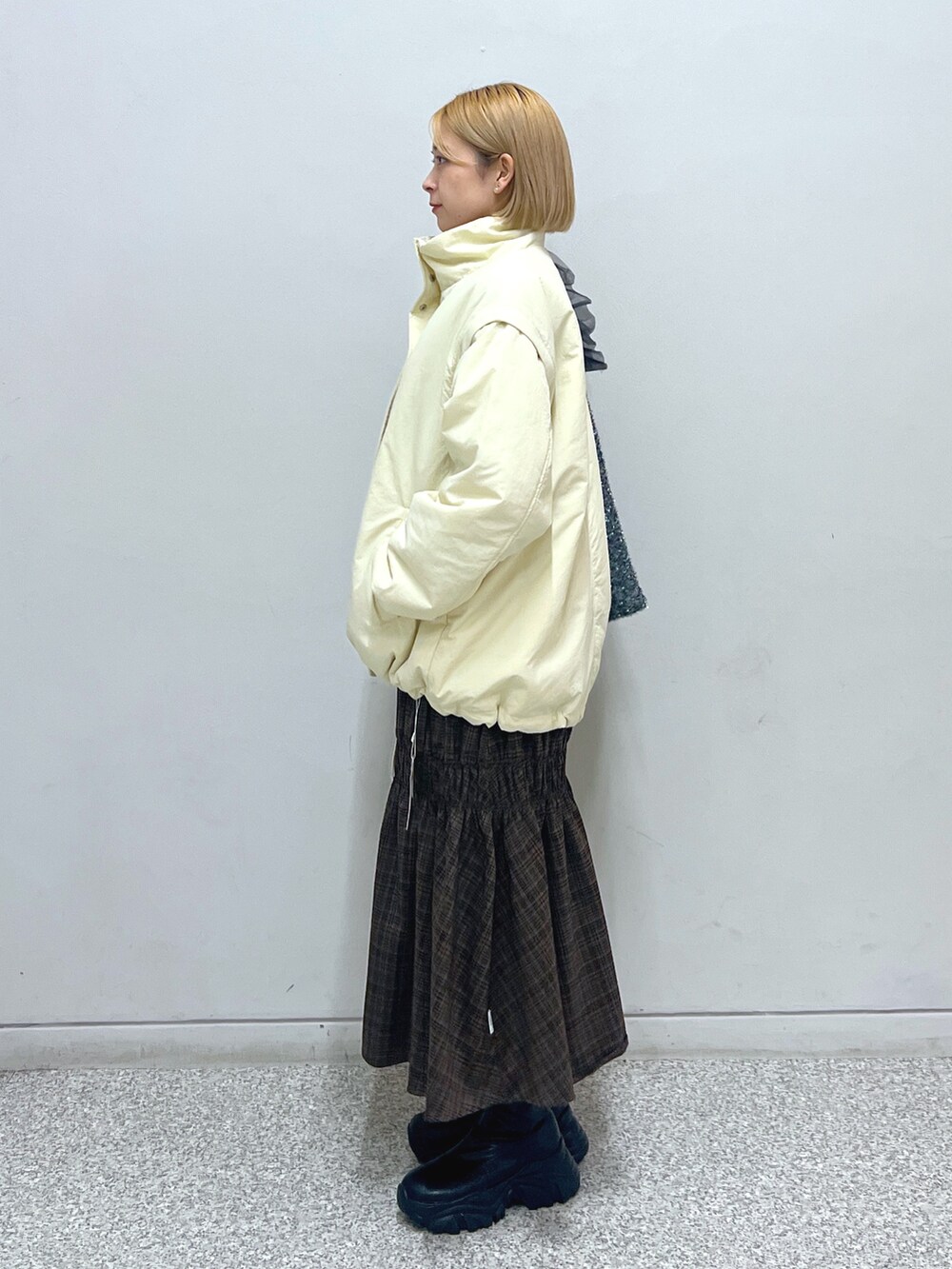 ホワイト系のスウェット、ホワイト系のダウンジャケット/コート、ブラウン系のスカートを着用したレディースの秋コーディネートの2枚目の写真