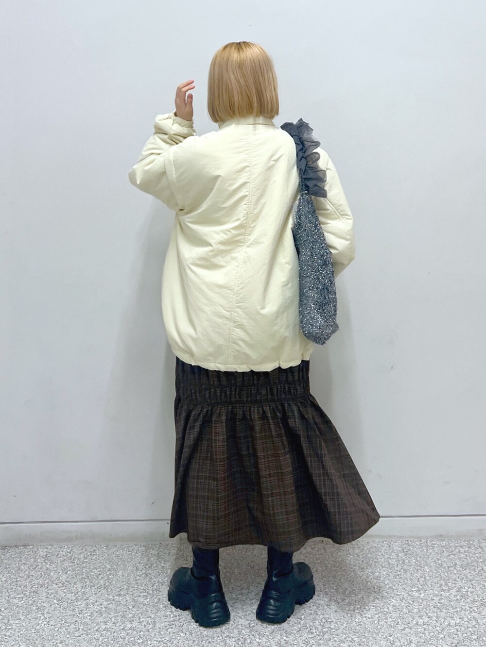 ホワイト系のスウェット、ホワイト系のダウンジャケット/コート、ブラウン系のスカートを着用したレディースの秋コーディネートの3枚目の写真