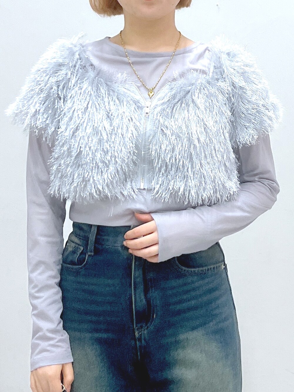 ブルー系のデニムパンツ、ベージュ系のブーツ、ブラック系のトートバッグを着用したレディースの秋コーディネートの4枚目の写真