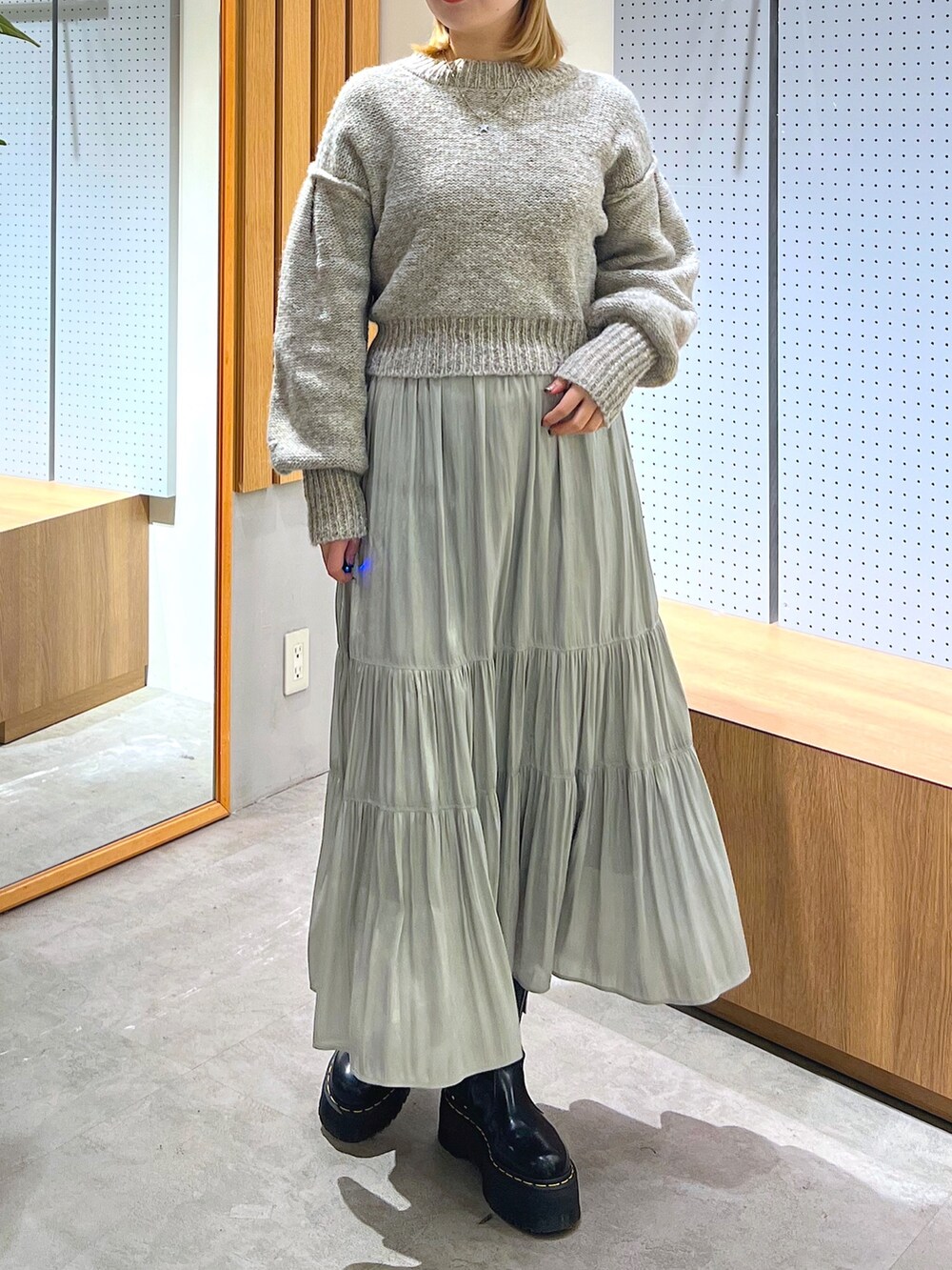 グレー系のニット/セーター、グリーン系のスカート、ホワイト系のニットキャップ/ビーニーを着用したレディースの冬コーディネートの5枚目の写真