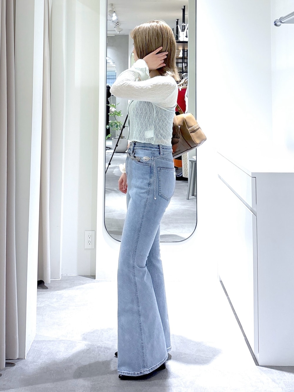 グリーン系のTシャツ/カットソー、ブルー系のデニムパンツ、ブラウン系のショルダーバッグを着用したレディースの夏コーディネートの2枚目の写真
