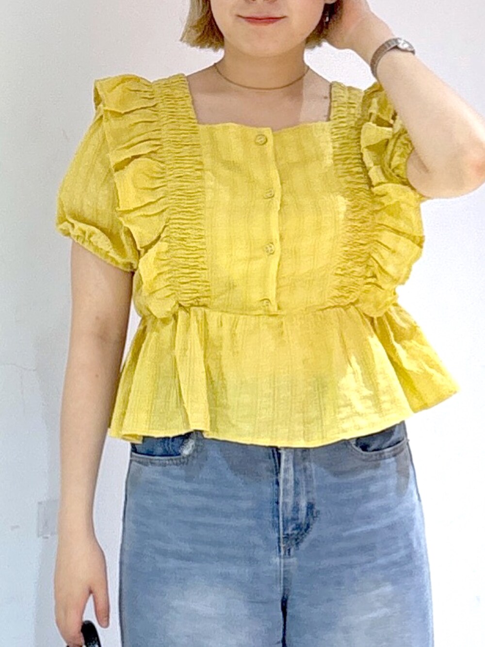 シルバー系のスニーカー、ブルー系のデニムパンツ、イエロー系のシャツ/ブラウスを着用したレディースの夏コーディネートの4枚目の写真