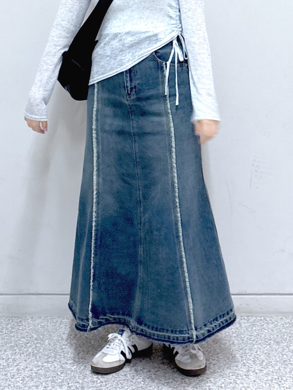 ブルー系のスカート、ブラック系のショルダーバッグ、ブルー系のTシャツ/カットソーを着用したレディースの春コーディネートの6枚目の写真