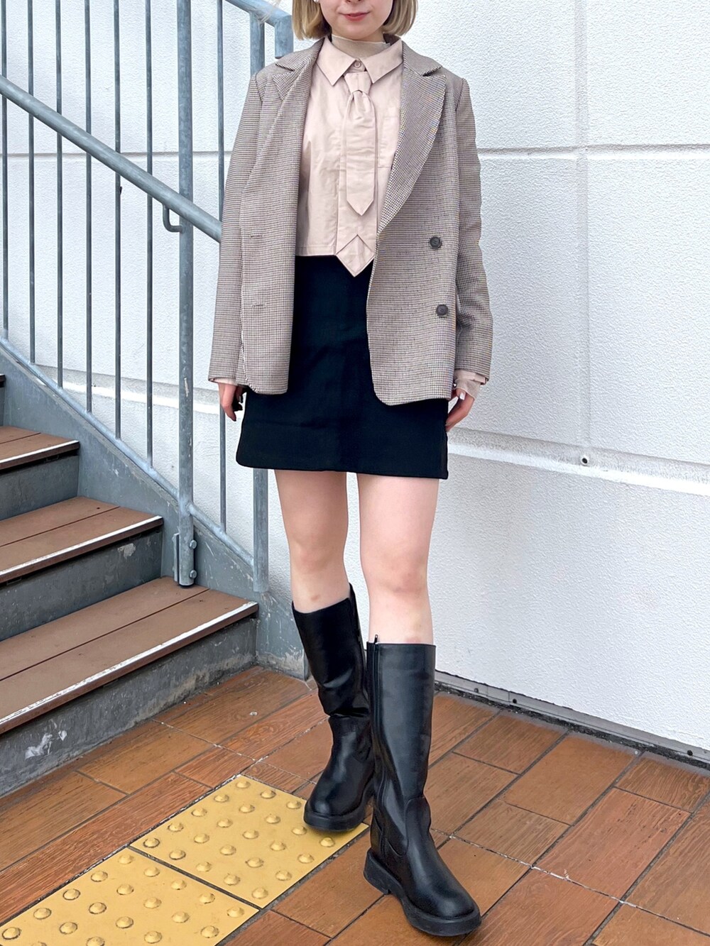 ブラウン系のテーラードジャケット、ベージュ系のシャツ/ブラウス、ブラック系のスカートを着用したレディースの冬コーディネートの2枚目の写真