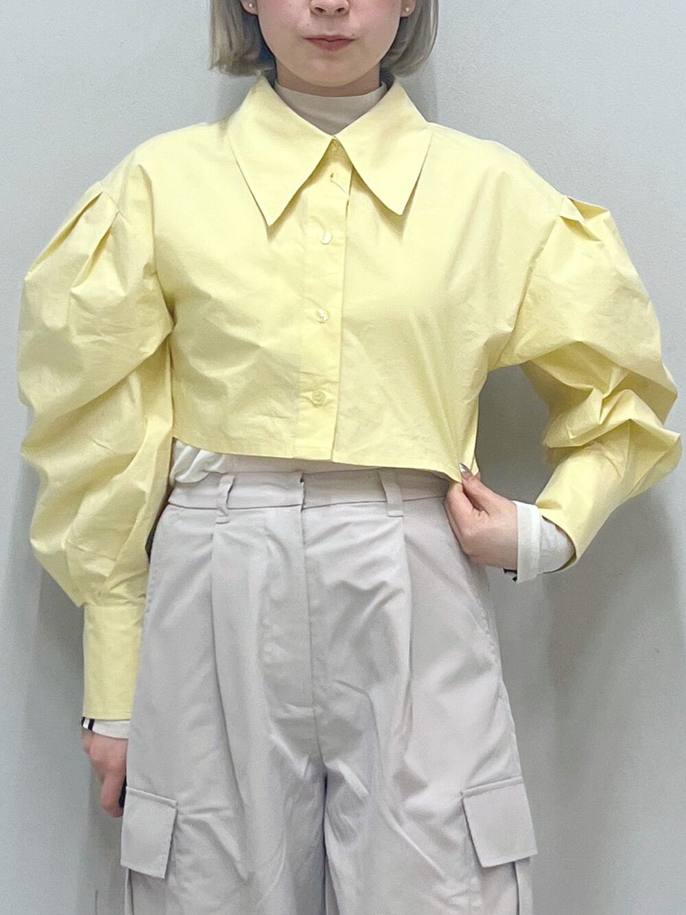 ベージュ系のカーゴパンツ、ゴールド系のパンプス、グリーン系のキャミソールを着用したレディースの春コーディネートの5枚目の写真