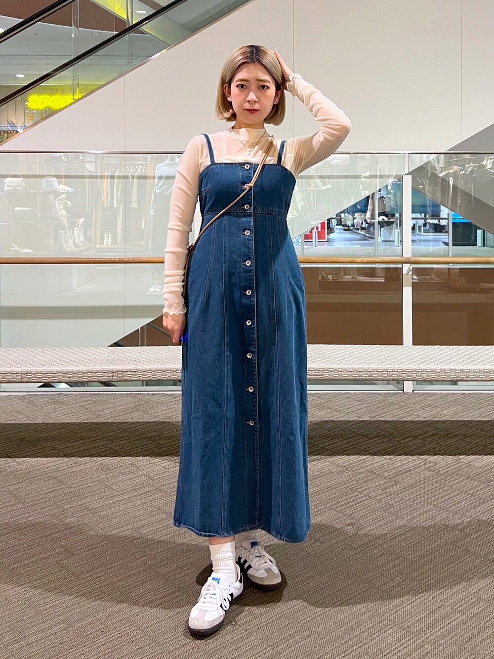 ブルー系のワンピース、ピンク系のハンドバッグ、ホワイト系のTシャツ/カットソーを着用したレディースの冬コーディネートの2枚目の写真
