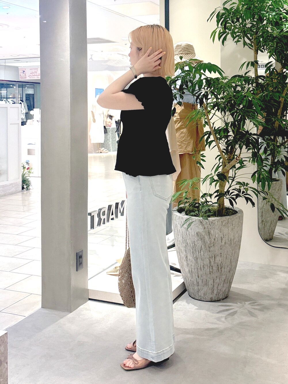 ブラック系のシャツ/ブラウス、ブルー系のデニムパンツ、ブラウン系のサンダルを着用したレディースの春コーディネートの2枚目の写真