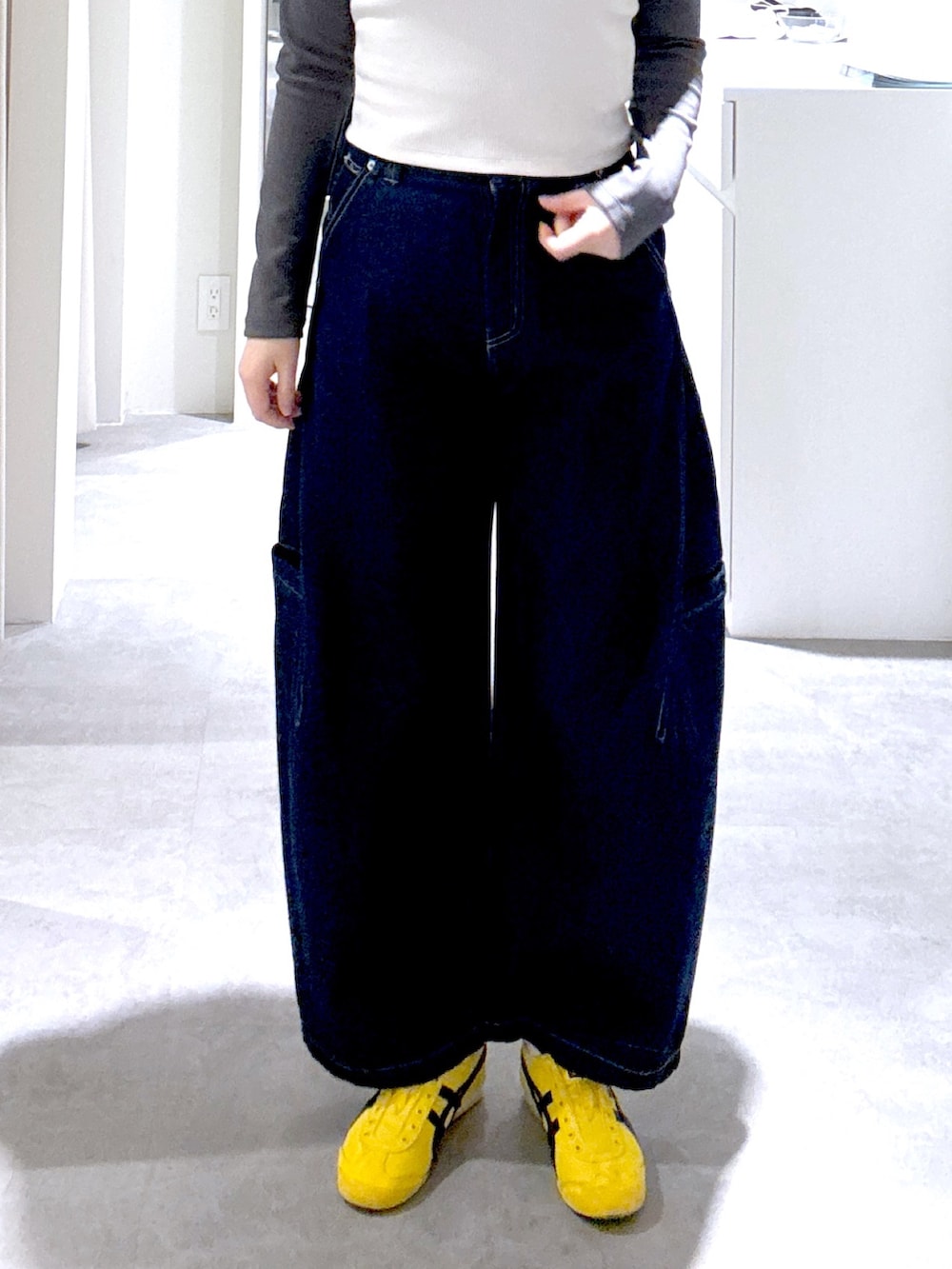 ブルー系のデニムパンツ、ブラック系のショルダーバッグ、ブラウン系のブルゾンを着用したレディースの冬コーディネートの4枚目の写真