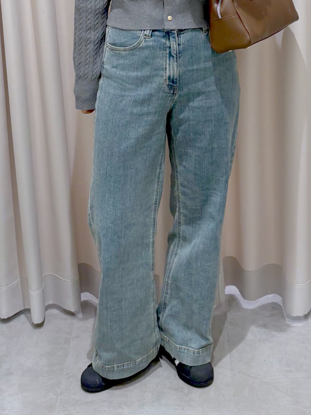 グレー系のカーディガン/ボレロ、ブルー系のデニムパンツを着用したレディースの秋コーディネートの5枚目の写真