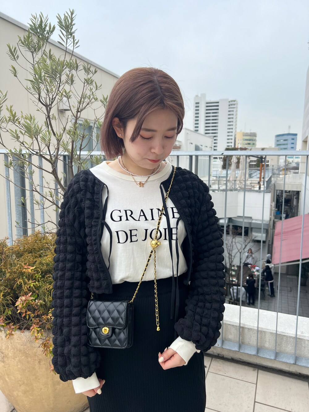 ブラック系のシャツ/ブラウス、ブラック系のスカート、ホワイト系のTシャツ/カットソーを着用したレディースの春コーディネートの2枚目の写真