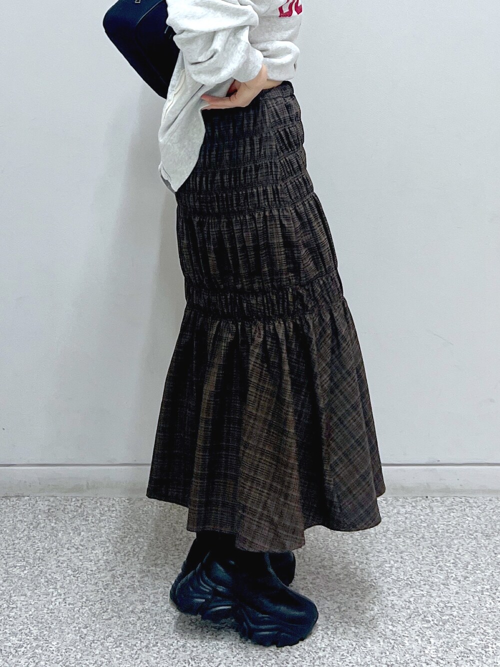 ホワイト系のスウェット、ホワイト系のダウンジャケット/コート、ブラウン系のスカートを着用したレディースの秋コーディネートの6枚目の写真