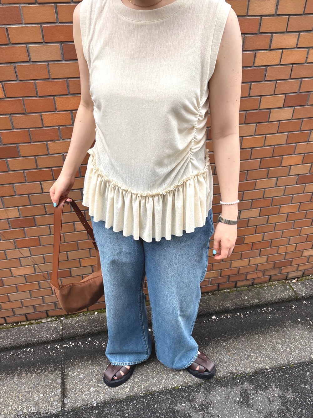 イエロー系のTシャツ/カットソー、ブルー系のデニムパンツ、ブラウン系のサンダルを着用したレディースの夏コーディネートの4枚目の写真