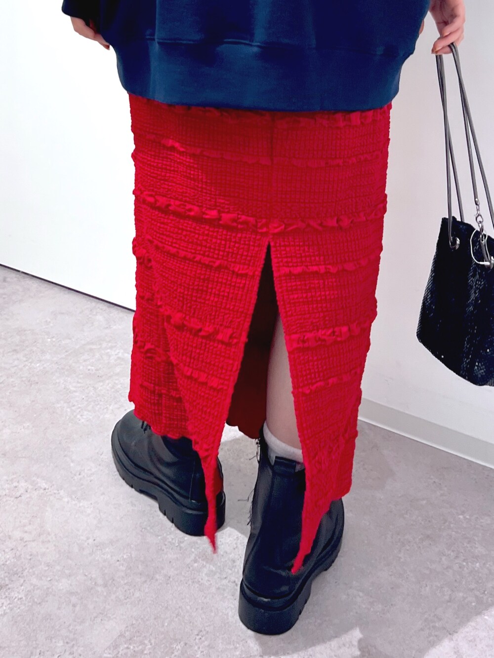 レッド系のスカート、ブルー系のスウェットを着用したレディースの秋コーディネートの6枚目の写真