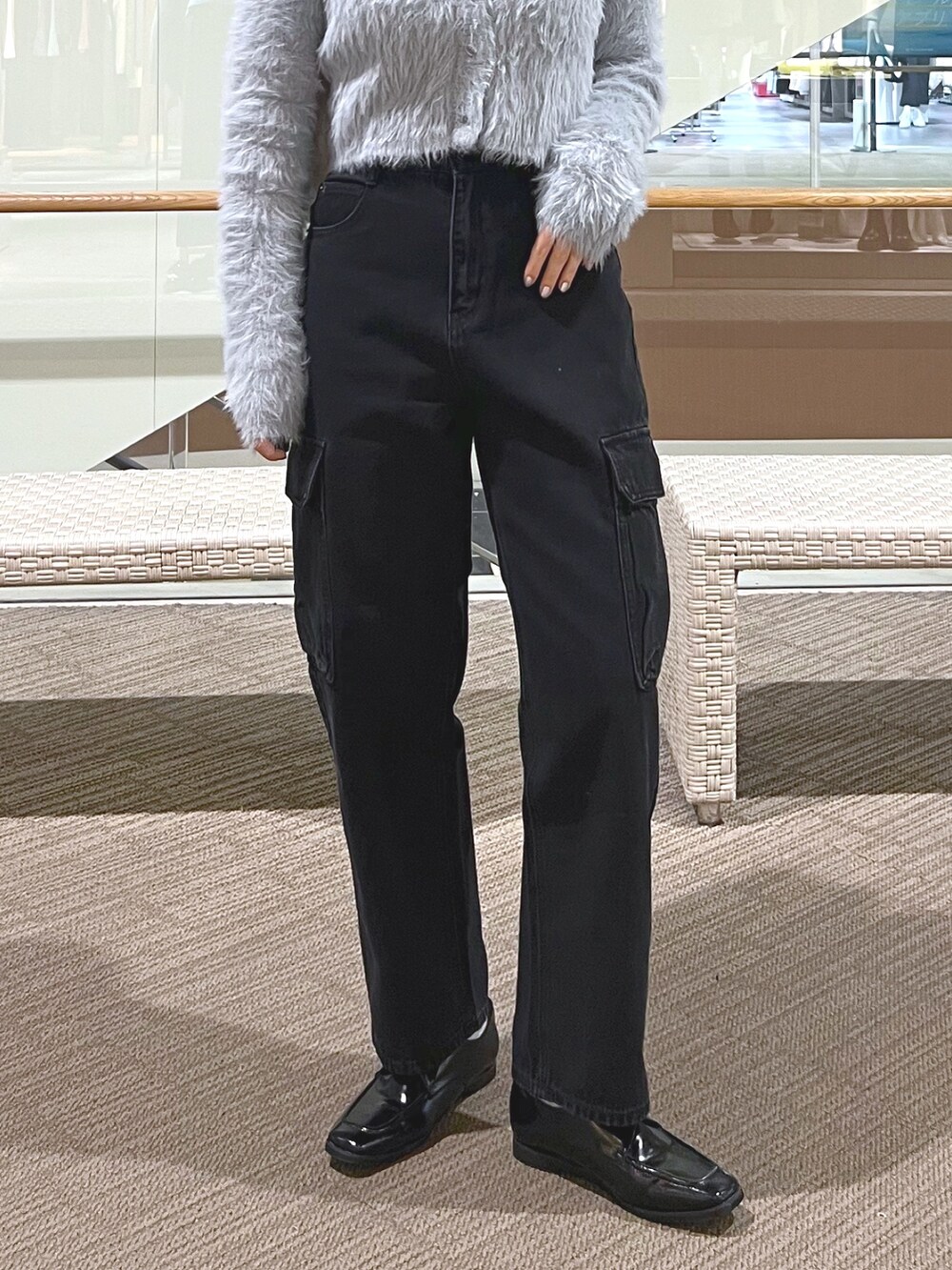 ブラック系のデニムパンツ、ブラック系のローファー、パープル系のショルダーバッグを着用したレディースの冬コーディネートの3枚目の写真