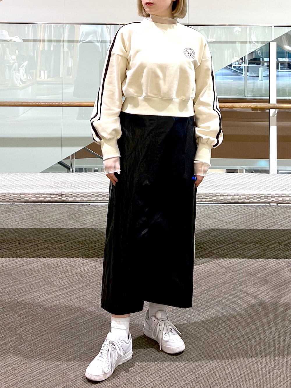 シルバー系のスカート、ピンク系のハンドバッグ、ホワイト系のスウェットを着用したレディースの冬コーディネートの4枚目の写真