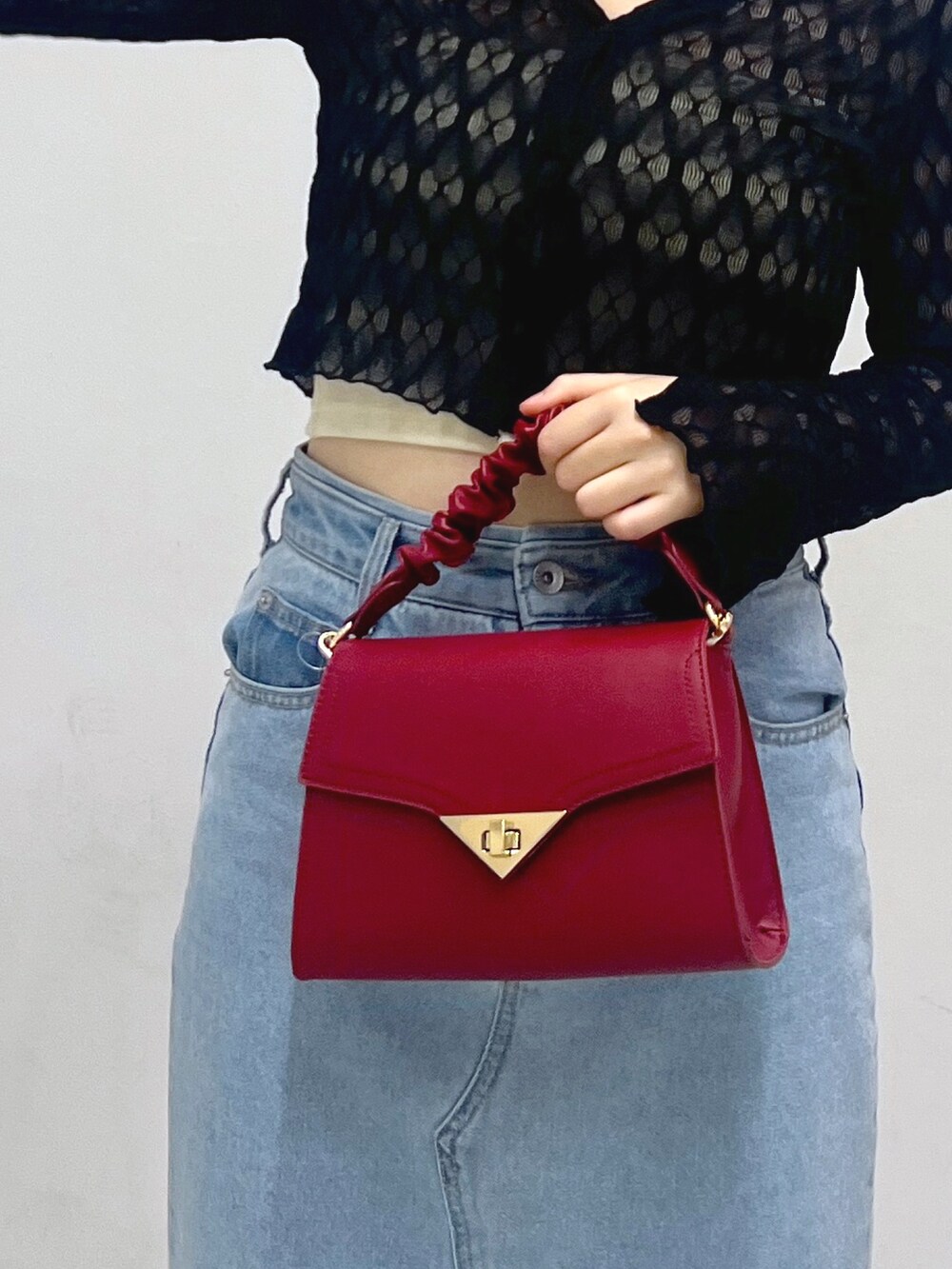 ブルー系のデニムスカート、ベージュ系のブーツ、レッド系のショルダーバッグを着用したレディースの秋コーディネートの7枚目の写真