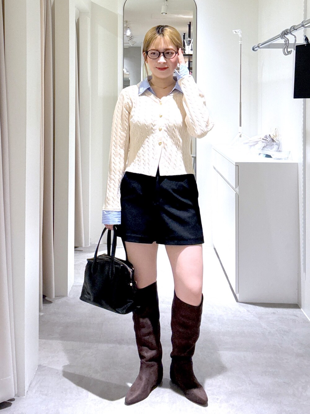 ホワイト系のニット/セーター、ブラック系のその他パンツ、ブラック系のボストンバッグを着用したレディースの冬コーディネートの2枚目の写真