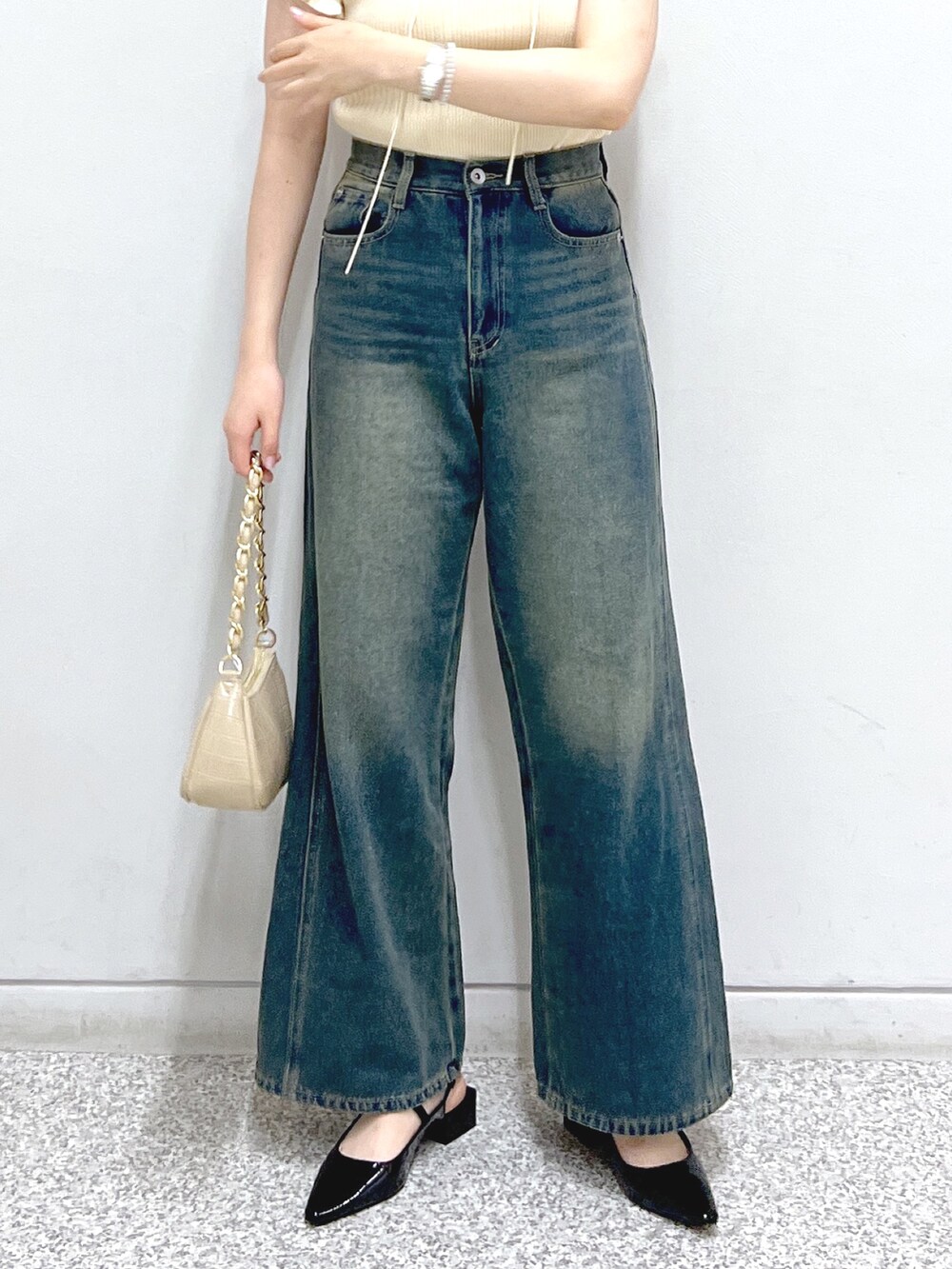 ブルー系のデニムパンツ、ブラック系のパンプス、ベージュ系のトートバッグを着用したレディースの夏コーディネートの5枚目の写真