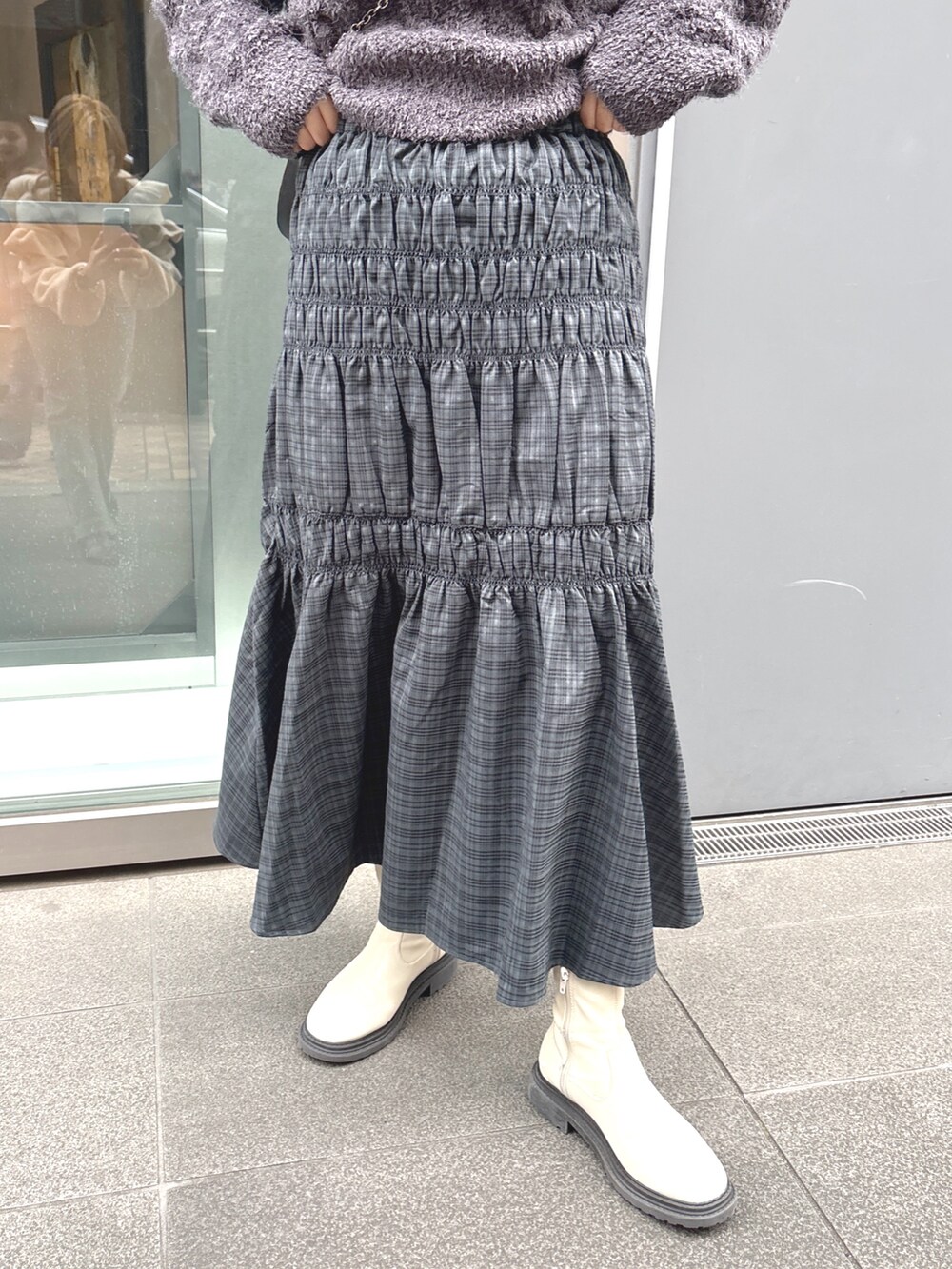 グレー系のスカート、グレー系のニット/セーター、ブラック系のショルダーバッグを着用したレディースの冬コーディネートの5枚目の写真