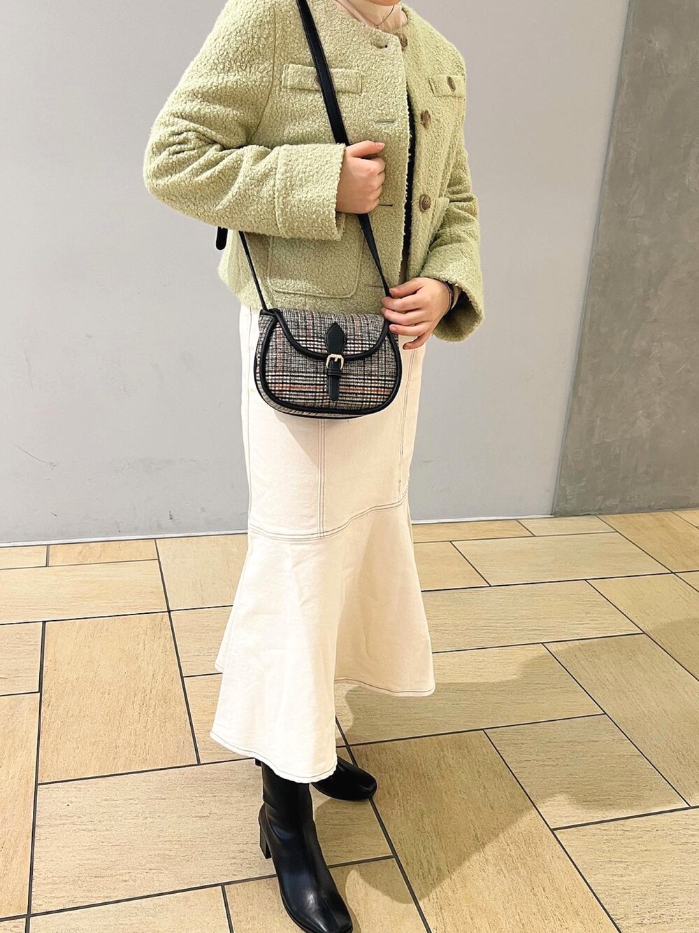 グリーン系のノーカラージャケット、ホワイト系のデニムスカート、ホワイト系のTシャツ/カットソーを着用したレディースの秋コーディネートの2枚目の写真