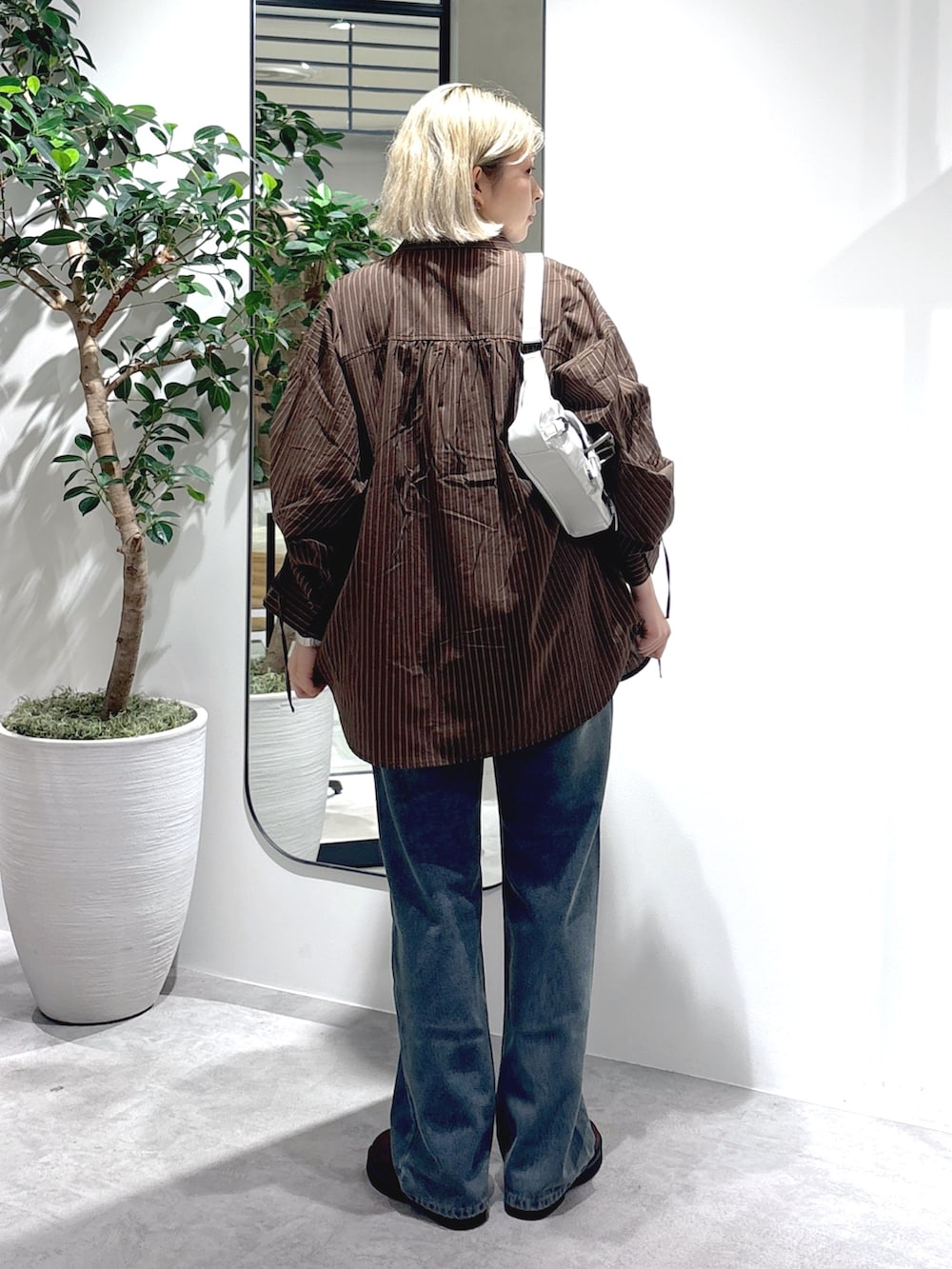 ブラウン系のシャツ/ブラウス、ブルー系のデニムパンツ、ホワイト系のTシャツ/カットソーを着用したレディースの秋コーディネートの3枚目の写真