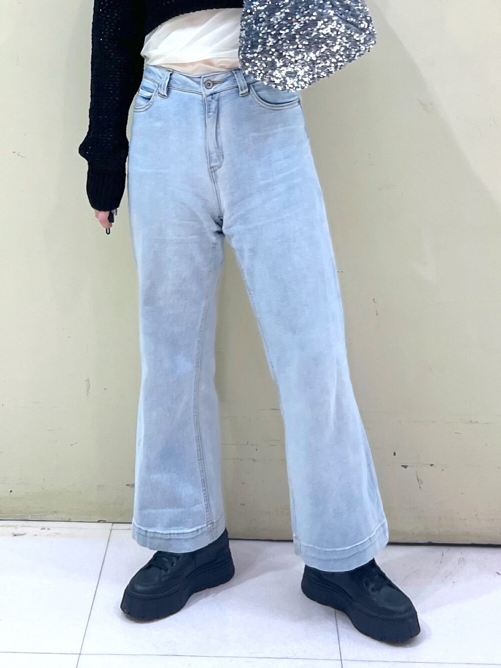 ブラック系のニット/セーター、ブルー系のデニムパンツ、シルバー系のハンドバッグを着用したレディースの春コーディネートの5枚目の写真