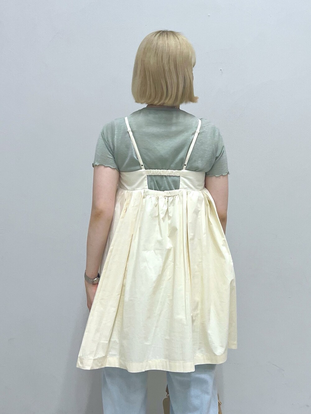 ブルー系のデニムパンツ、ホワイト系のハンドバッグ、グリーン系のTシャツ/カットソーを着用したレディースの夏コーディネートの4枚目の写真