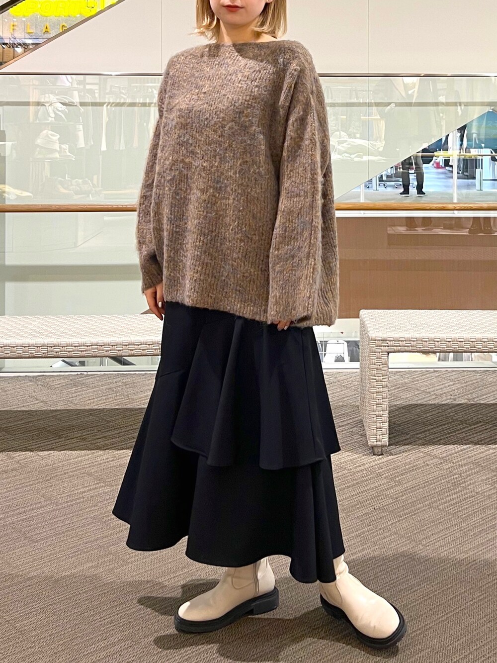 ブラック系のスカート、ベージュ系のニット/セーター、ホワイト系のショルダーバッグを着用したレディースの冬コーディネートの4枚目の写真