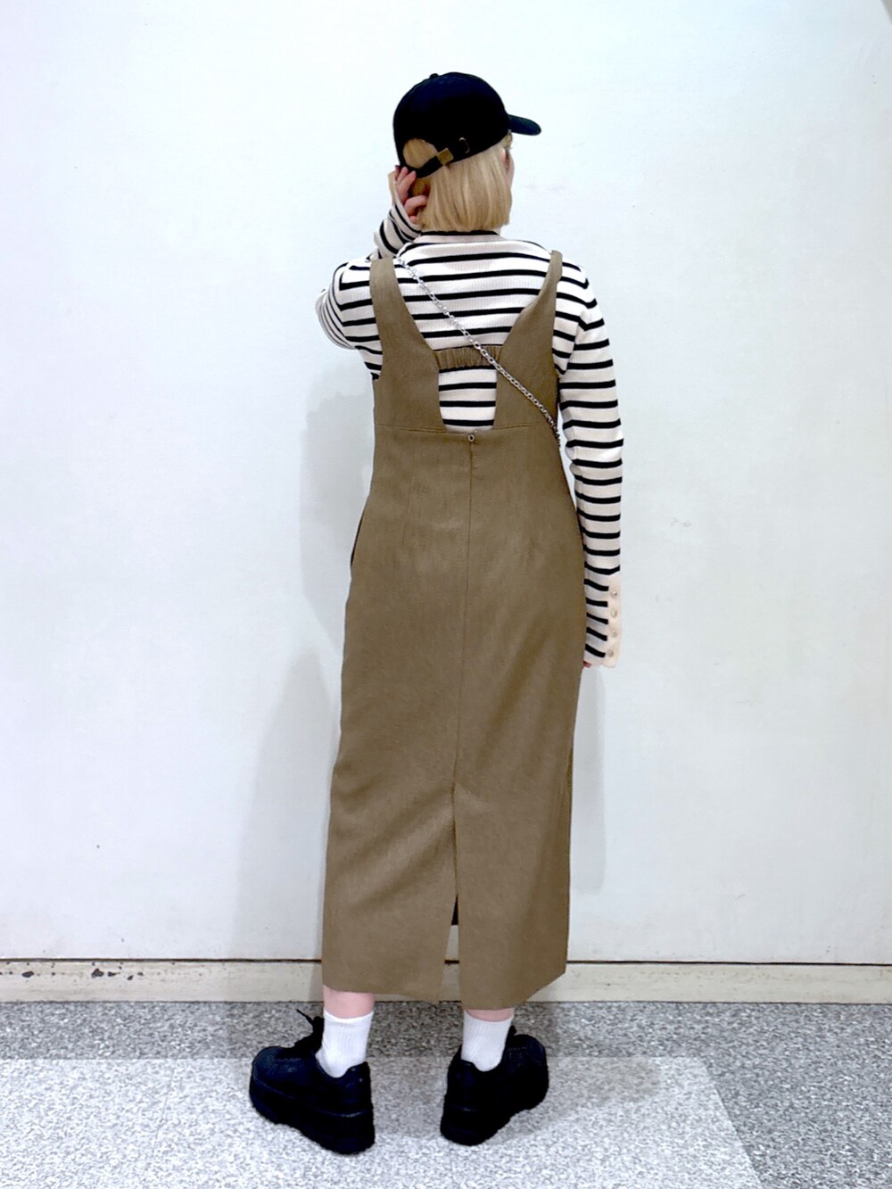 ブラック系のショルダーバッグ、ブラウン系のジャンパースカート、ベージュ系のニット/セーターを着用したレディースの冬コーディネートの4枚目の写真