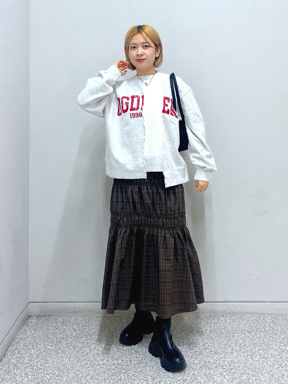 ホワイト系のスウェット、ホワイト系のダウンジャケット/コート、ブラウン系のスカートを着用したレディースの秋コーディネートの4枚目の写真