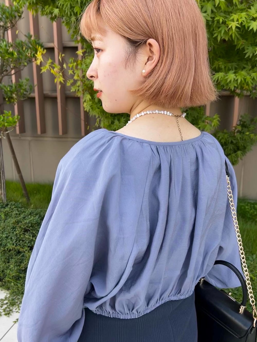 ブルー系のワンピース、ブラック系のハンドバッグを着用したレディースの秋コーディネートの3枚目の写真