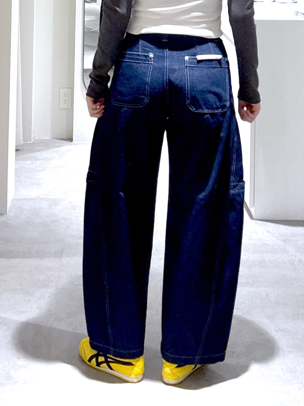 ブルー系のデニムパンツ、ブラック系のショルダーバッグ、ブラウン系のブルゾンを着用したレディースの冬コーディネートの6枚目の写真