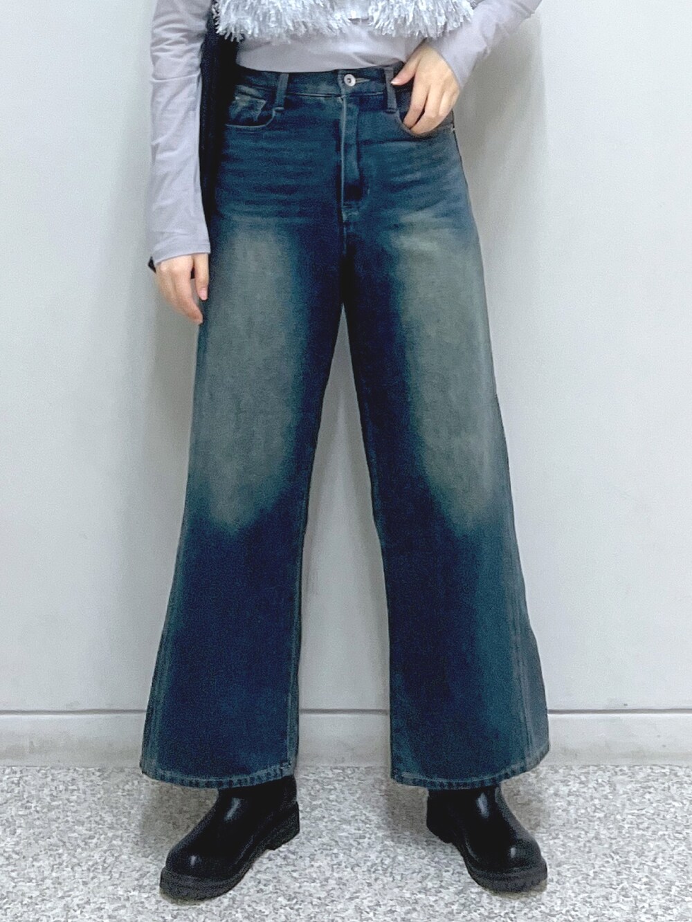 ブルー系のデニムパンツ、ベージュ系のブーツ、ブラック系のトートバッグを着用したレディースの秋コーディネートの6枚目の写真