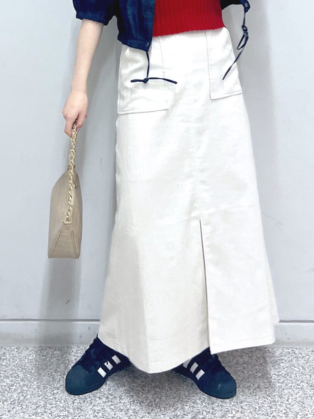 ホワイト系のスカート、ベージュ系のトートバッグ、レッド系のタンクトップを着用したレディースの秋コーディネートの6枚目の写真