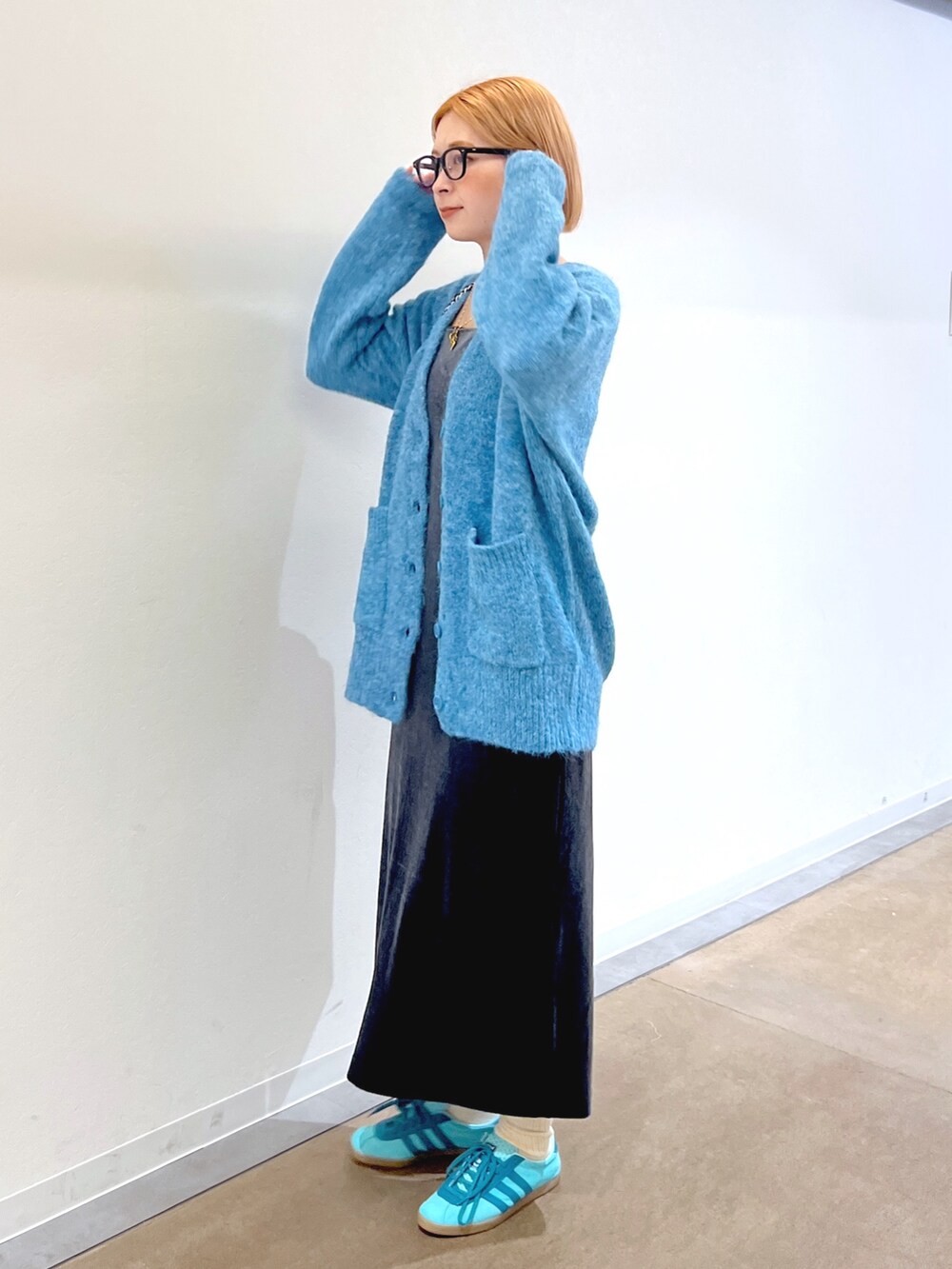 グレー系のワンピース、ブルー系のカーディガン/ボレロ、ブラウン系のトートバッグを着用したレディースの秋コーディネートの2枚目の写真