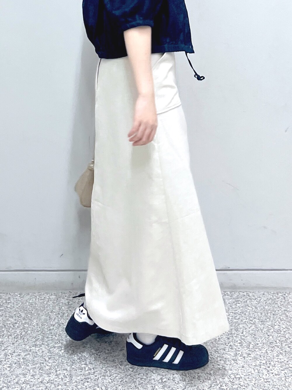 ホワイト系のスカート、ベージュ系のトートバッグ、レッド系のタンクトップを着用したレディースの秋コーディネートの7枚目の写真