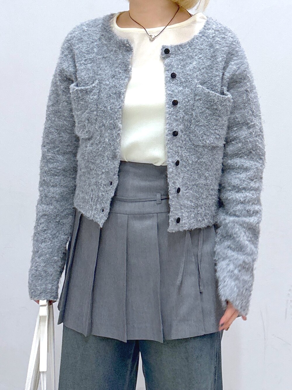 ブルー系のデニムパンツ、グレー系のスカート、グレー系のカーディガン/ボレロを着用したレディースの春コーディネートの4枚目の写真