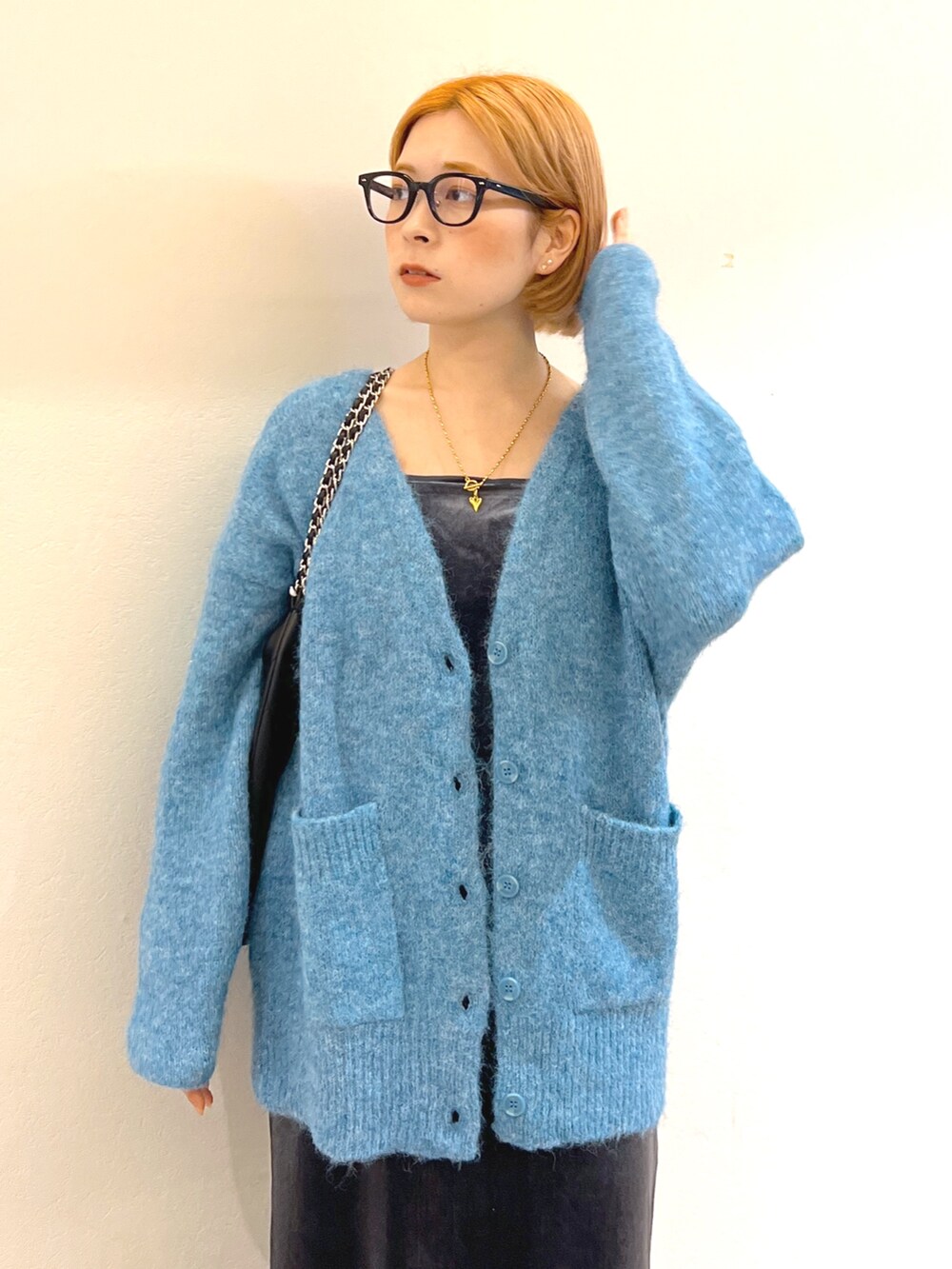 グレー系のワンピース、ブルー系のカーディガン/ボレロ、ブラウン系のトートバッグを着用したレディースの秋コーディネートの4枚目の写真